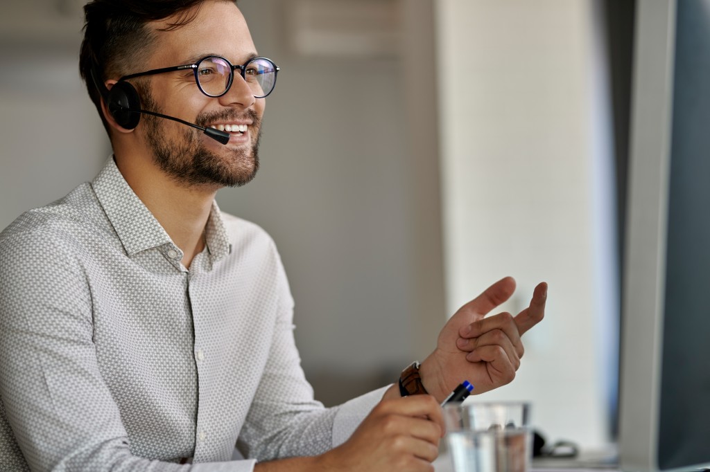 Happy customer service representative working on desktop PC at c