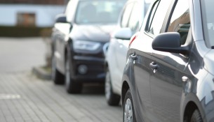 closeup-shot-black-car-parking-lot-with-blurred-background