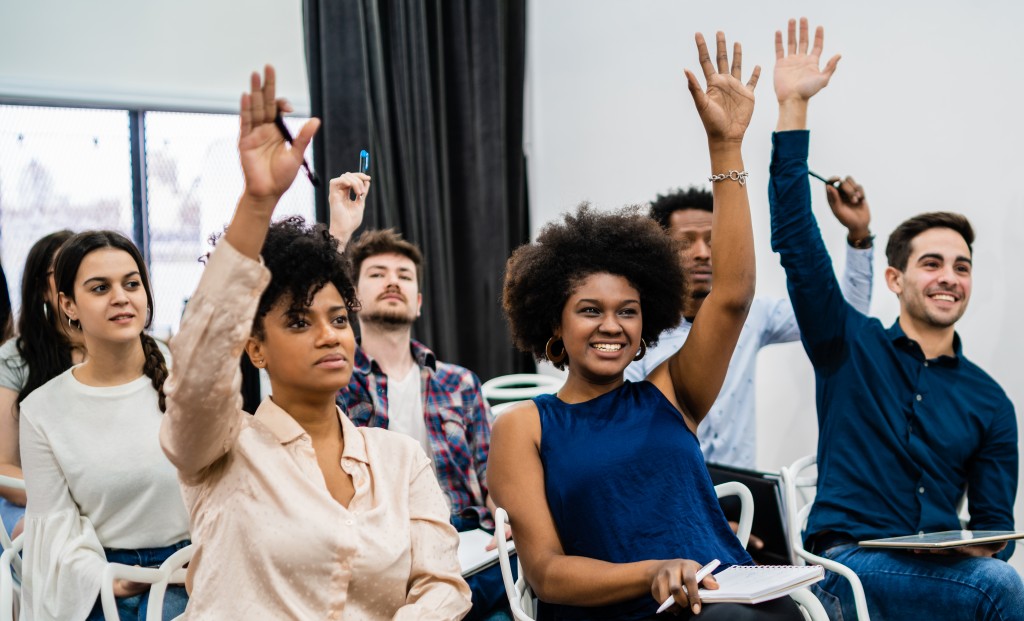 Group of young people sitting on conference together.