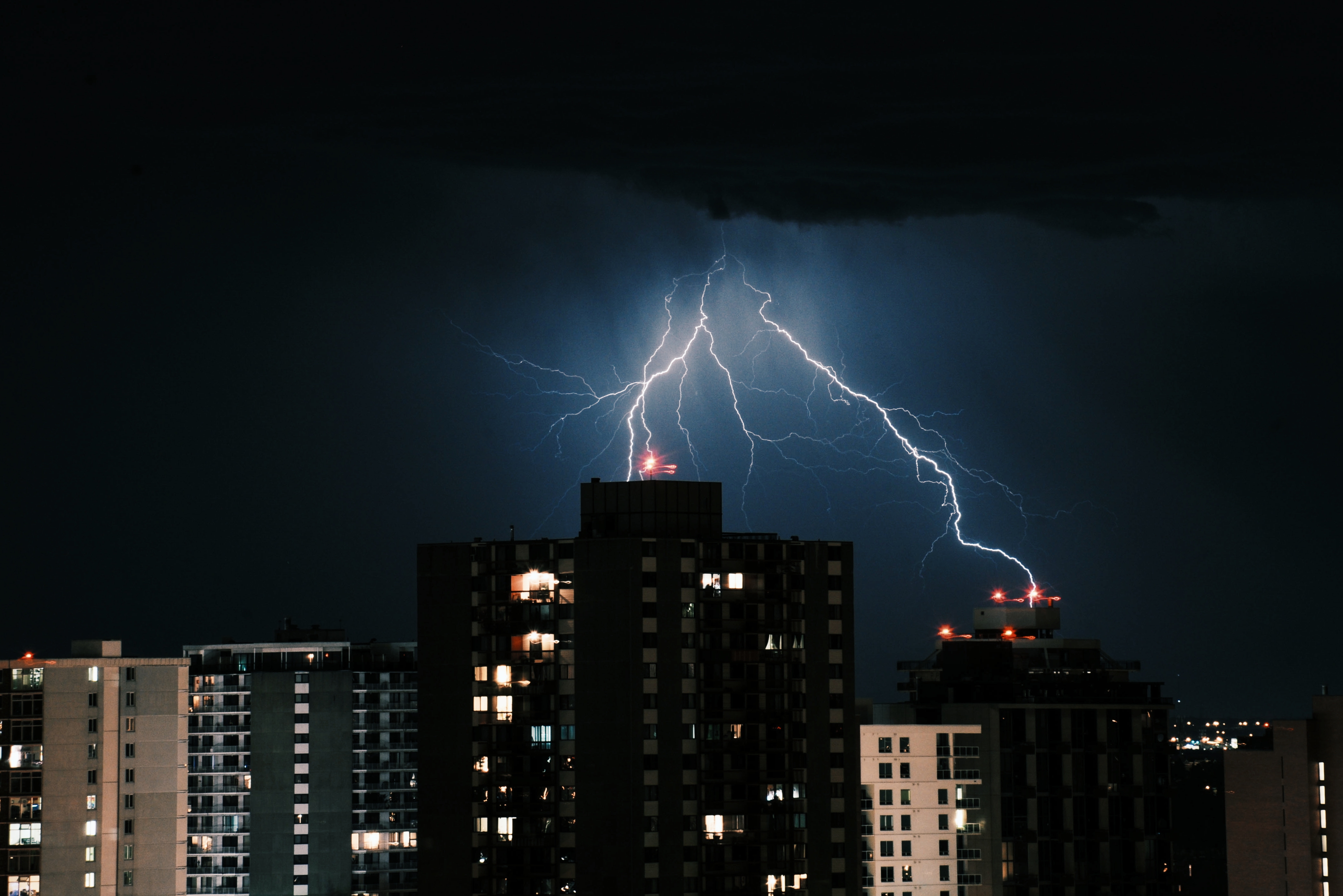 Lightning in the dark sky over the buildings in the city at night