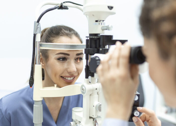 Eye doctor with female patient during an examination in modern clinic. Ophthalmologist is using special medical equipment for eye health
