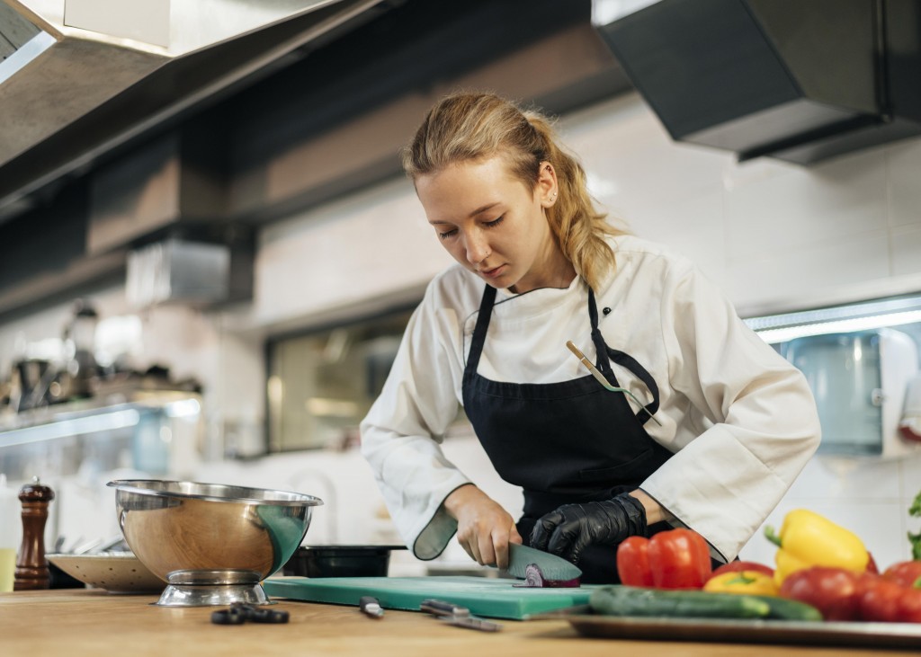 female-chef-chopping-vegetables-kitchen