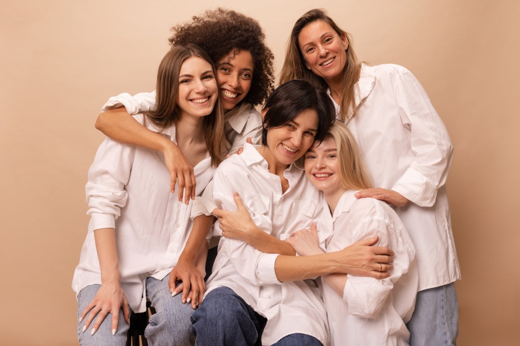 beautiful-diverse-young-ladies-jeans-white-shirts-look-camera-beige-background-women-s-day-concept