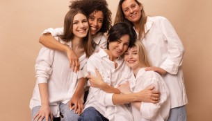 beautiful-diverse-young-ladies-jeans-white-shirts-look-camera-beige-background-women-s-day-concept