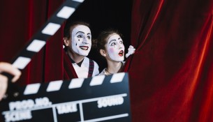clapperboard-front-excited-mime-couple-peeking-red-curtain