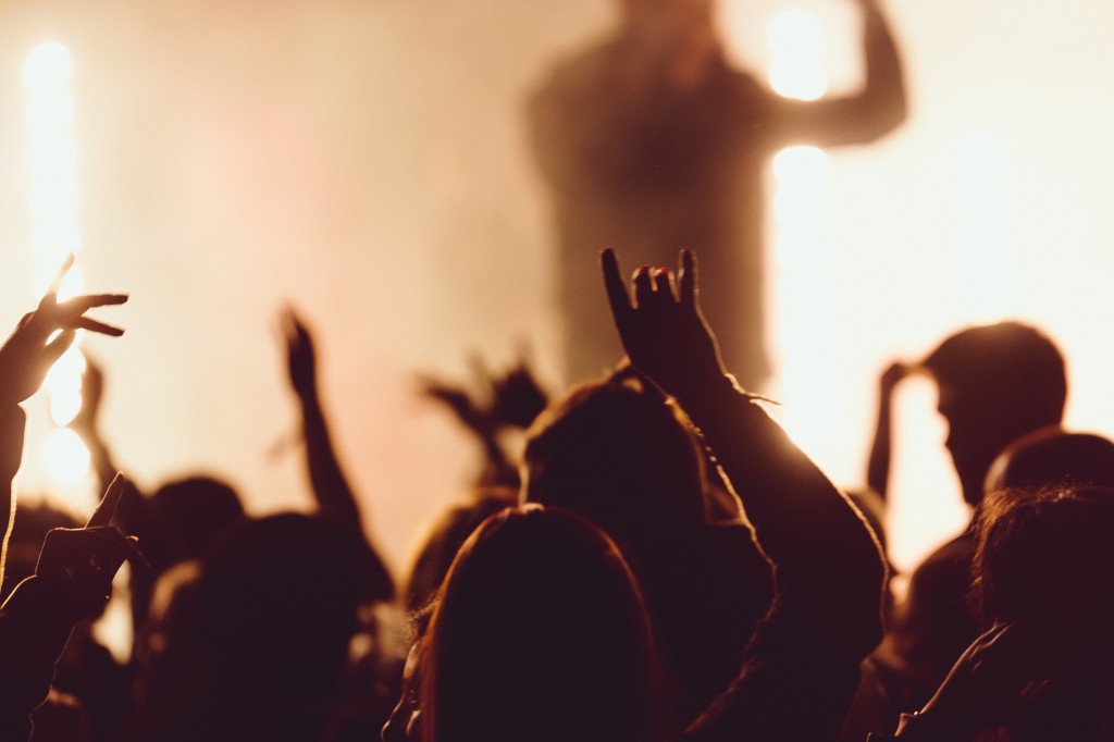 Dancing at a concert while the singer is performing surrounded with lights