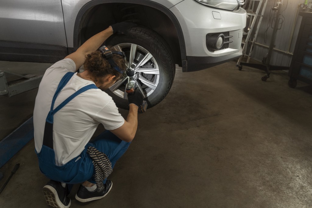 male-mechanic-working-shop-car