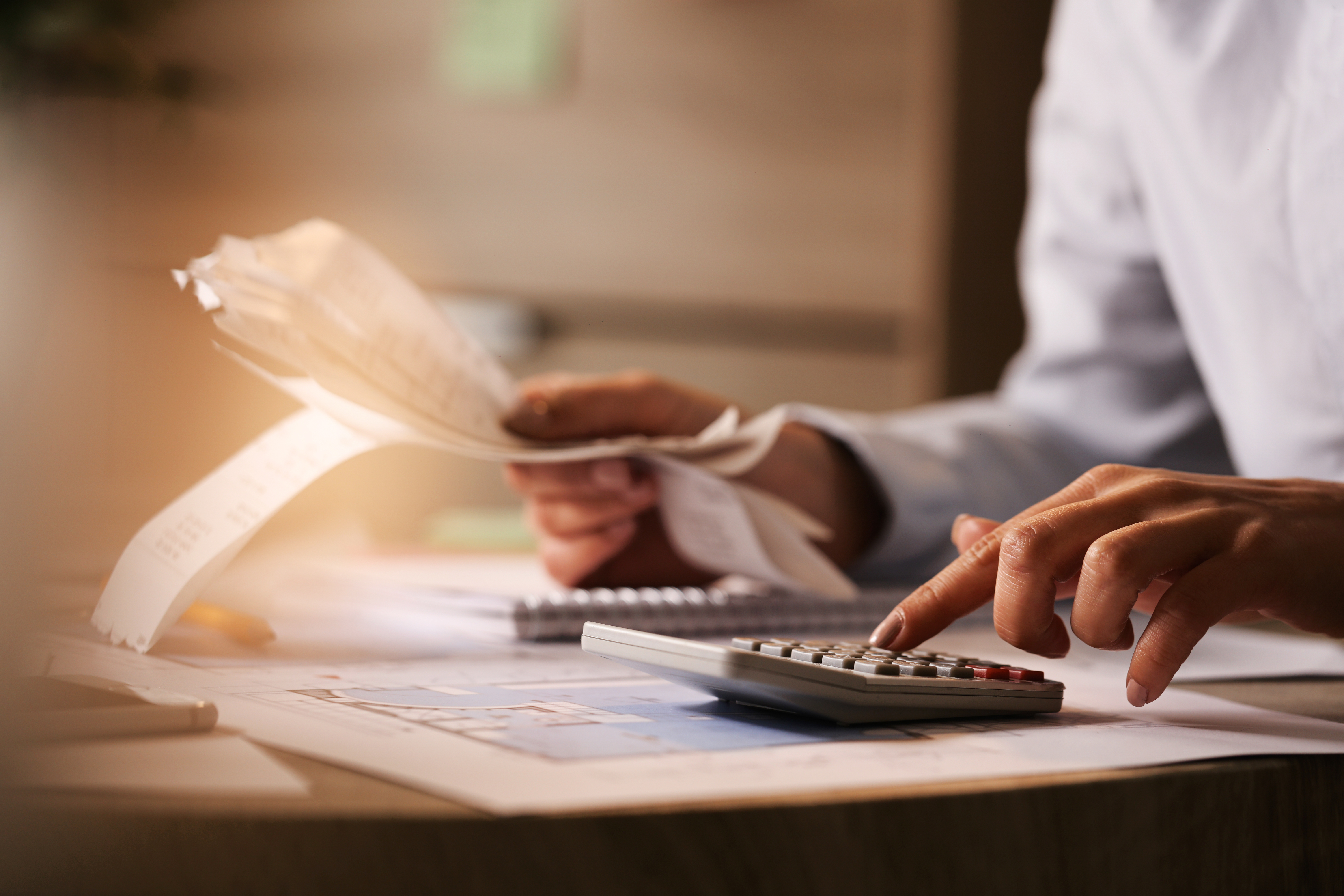 Close-up of business accountant using calculator while working i