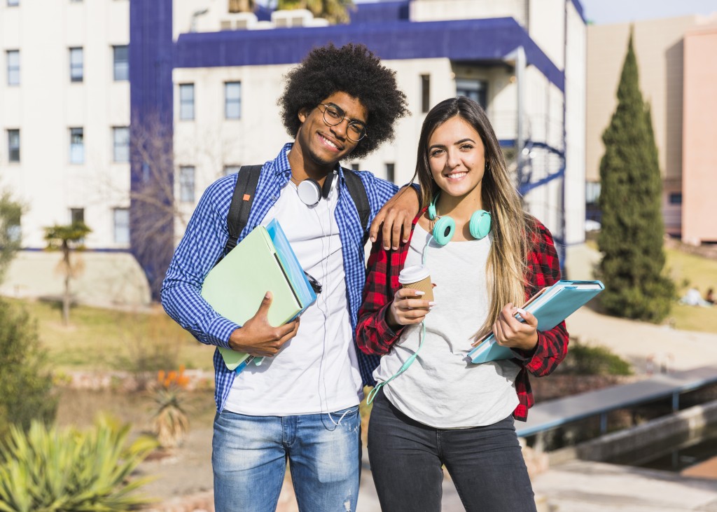 happy-mixed-race-couple-posing-front-university-building