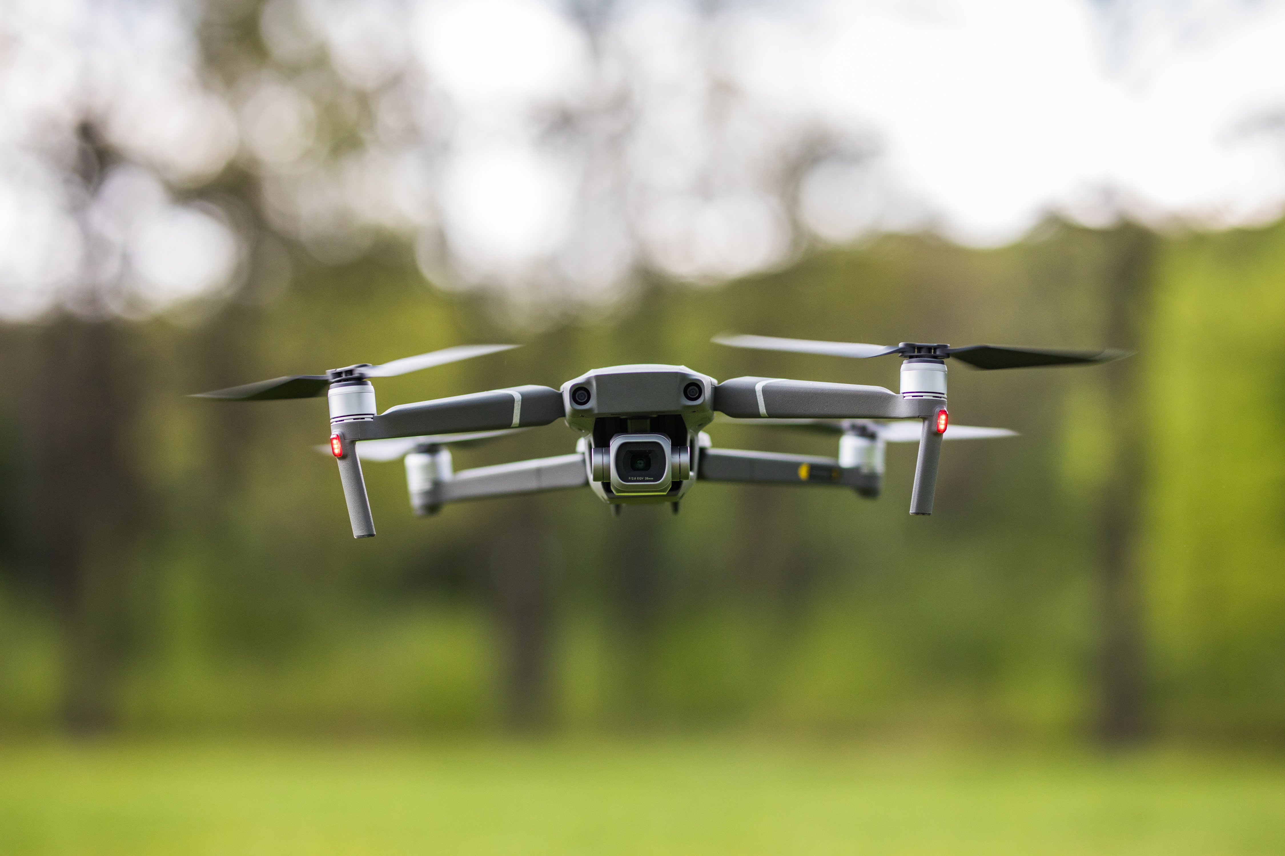 Quadcopter flying on a clear sunny green day background