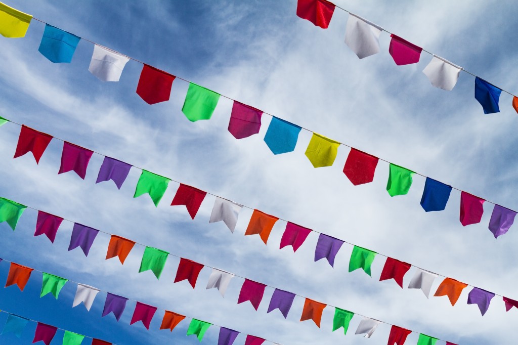 Small cute colorful flags on rope hanging outside for holiday wi