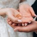 Groom holds bride's hands, where are two wedding rings