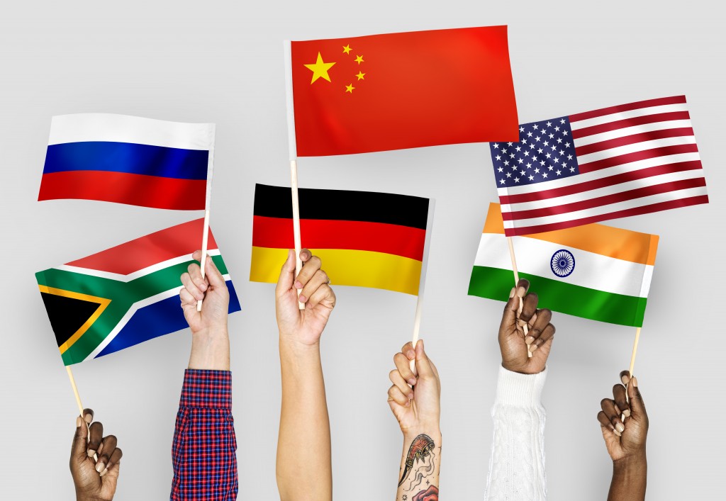 Hands waving flags of China, Germany, India, South Africa, and Russia