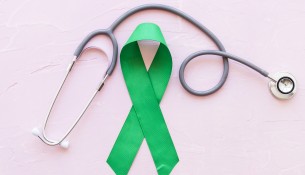 stethoscope-green-awareness-ribbon-pink-background