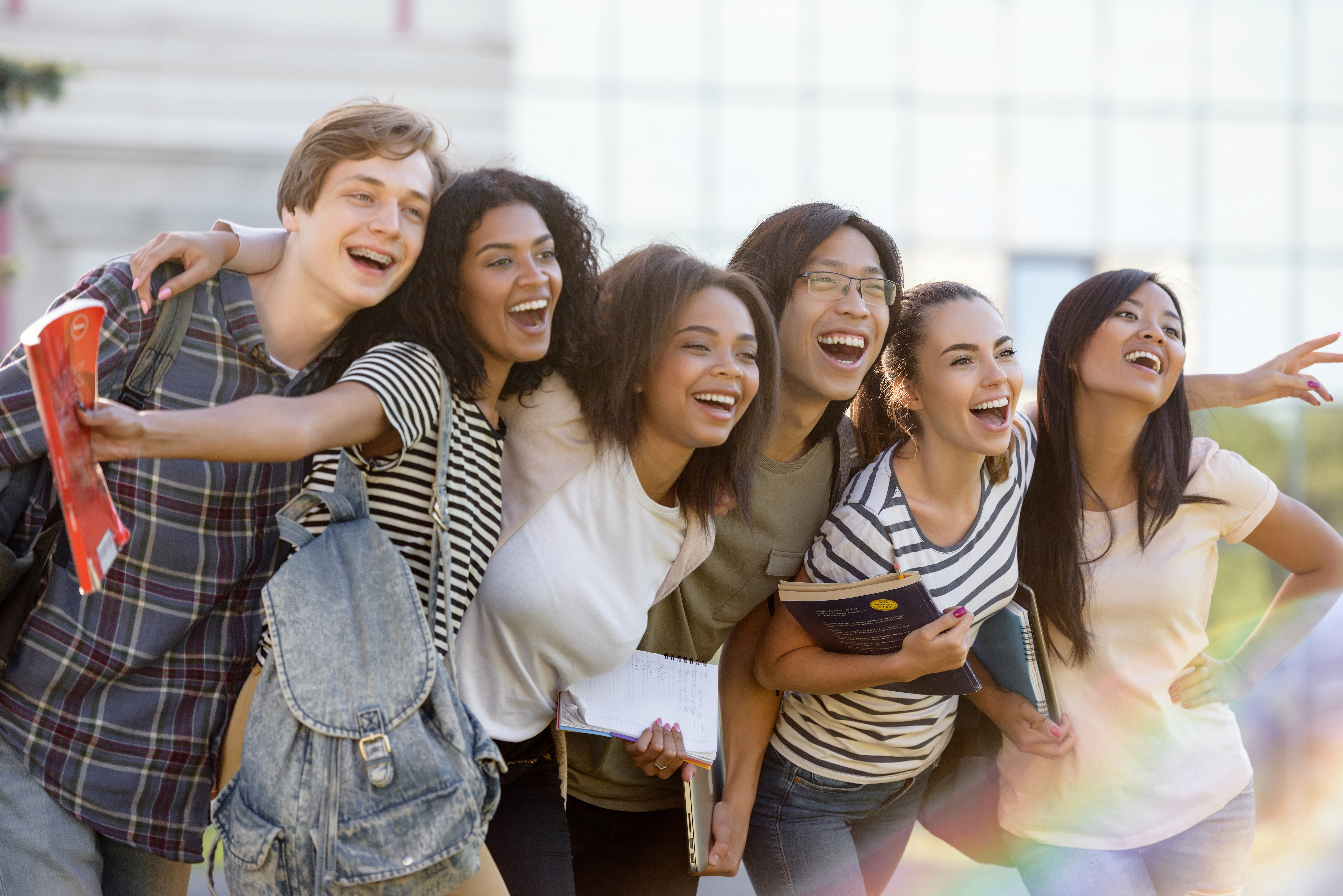 Multiethnic group of young happy students standing outdoors