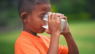 Little boy drinking milk in the park