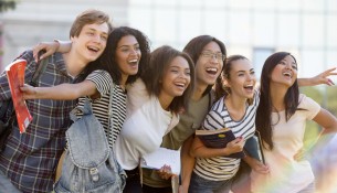 Multiethnic group of young happy students standing outdoors