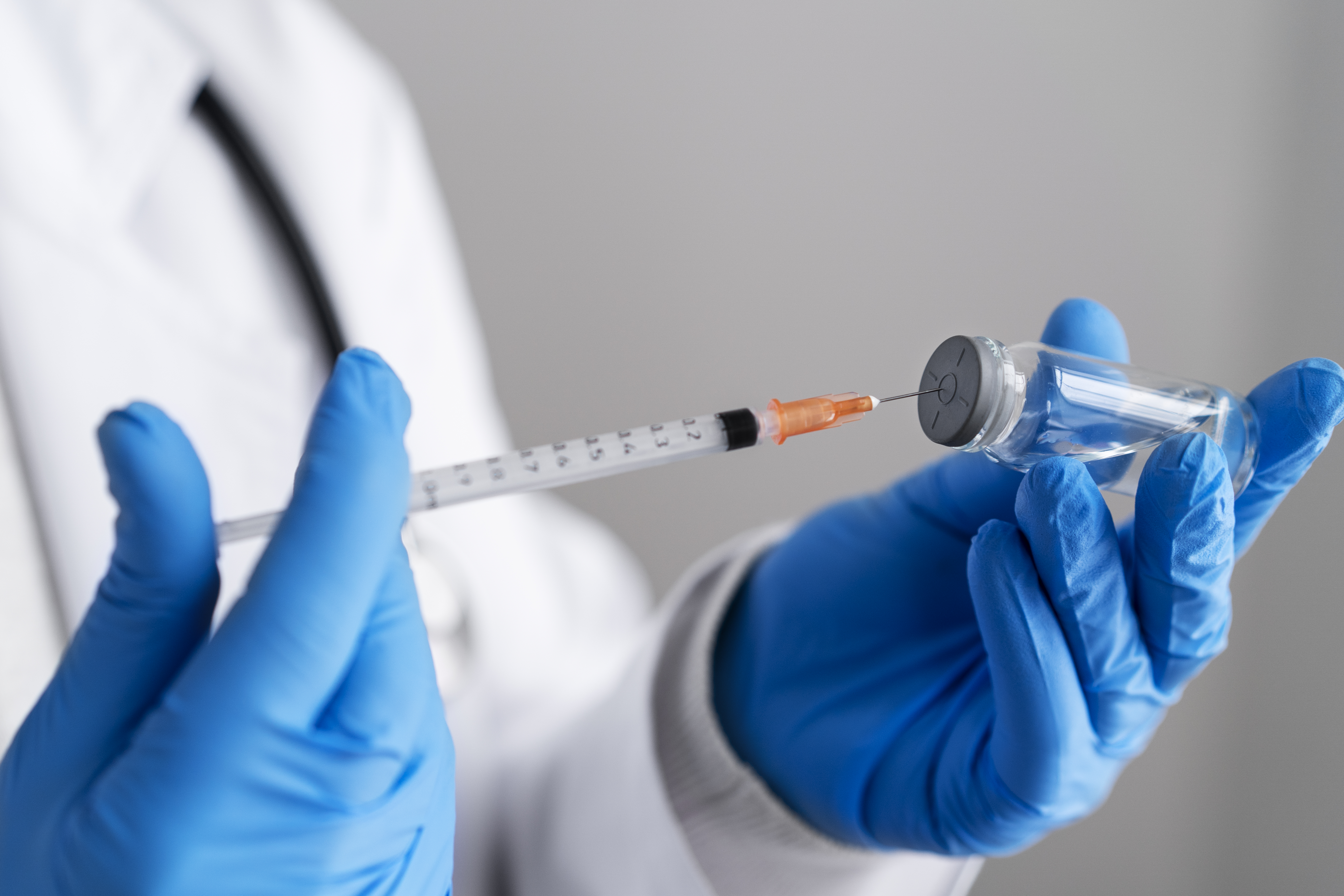 side-view-doctor-holding-syringe-vial