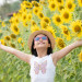 happy little asian girl having fun among blooming sunflowers und