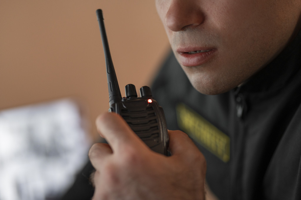 portrait-male-security-guard-with-radio-station-camera-screens