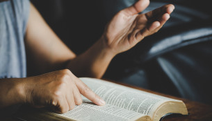 Spirituality and religion, Hands folded in prayer on a Holy Bibl