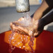 african-woman-pouring-water-recipient-outdoors