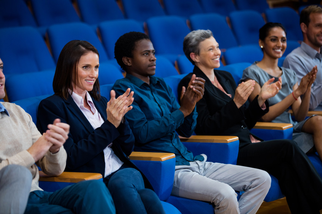 Business executives applauding in a business meeting at conference center