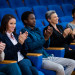 Business executives applauding in a business meeting at conference center