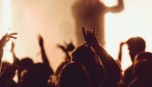 Dancing at a concert while the singer is performing surrounded with lights