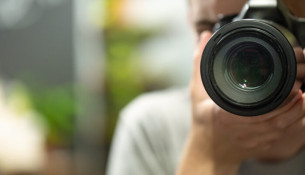 Reflection in the mirror of a man with a camera copy space.