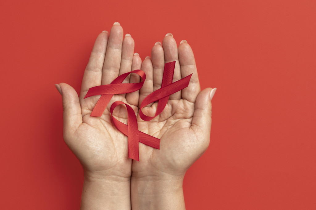 person-holding-world-aids-day-ribbon-symbol