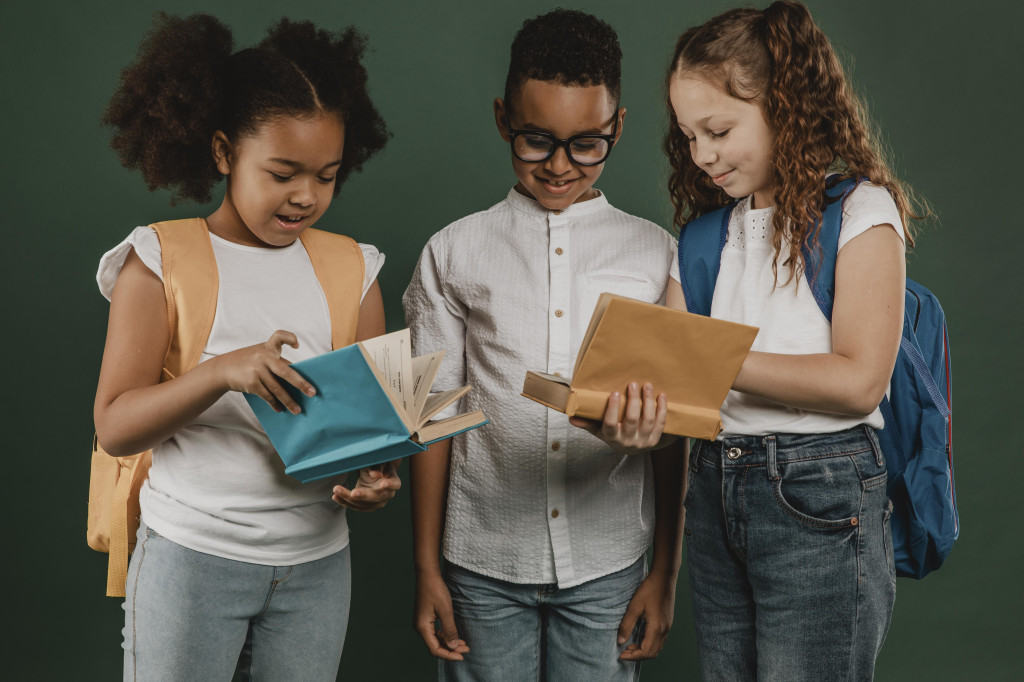 school-colleagues-looking-through-books-together